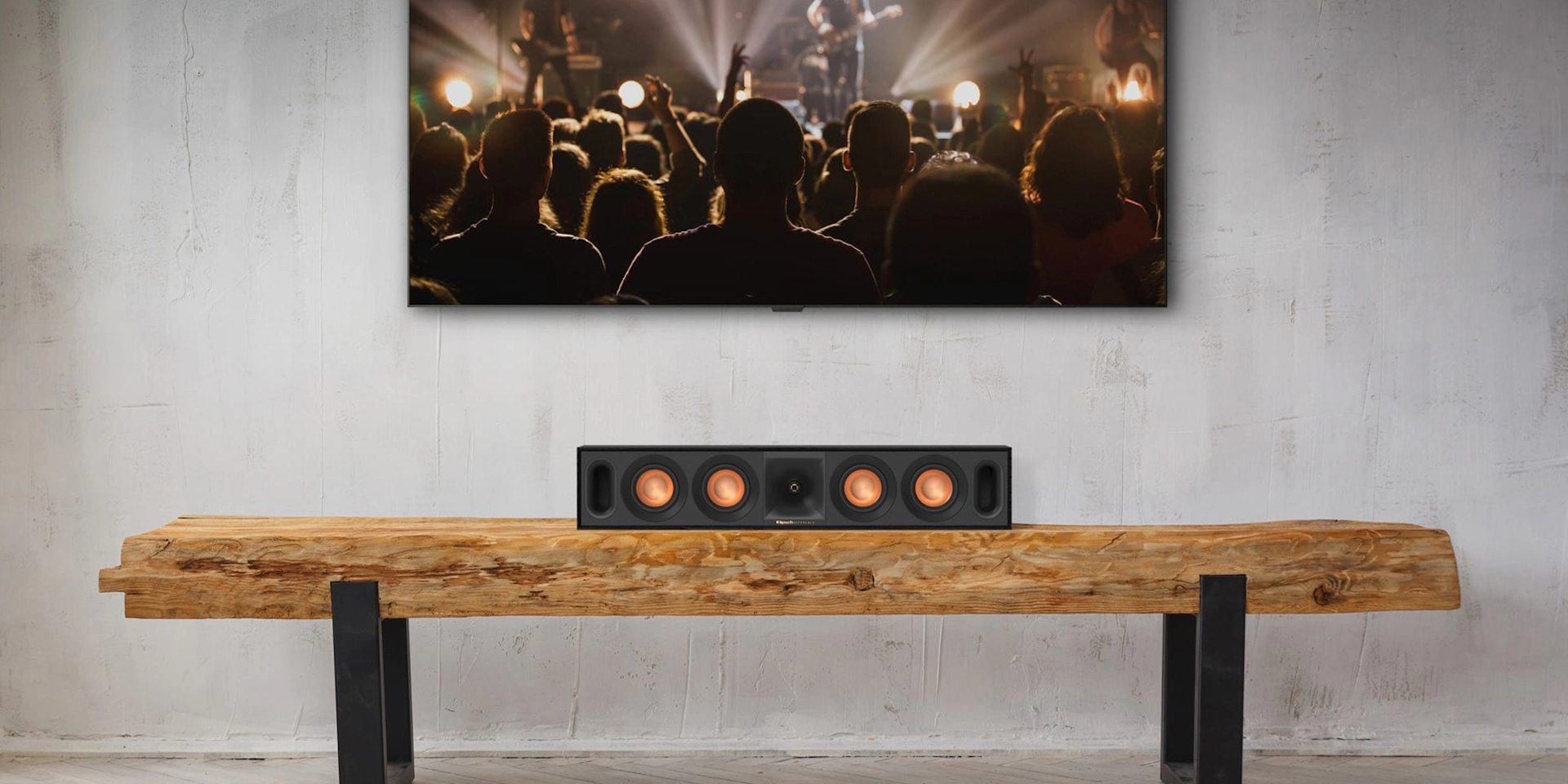 Klipsch R-30C Center Channel on wooden bench below a wall-mounted tv 2000x1000